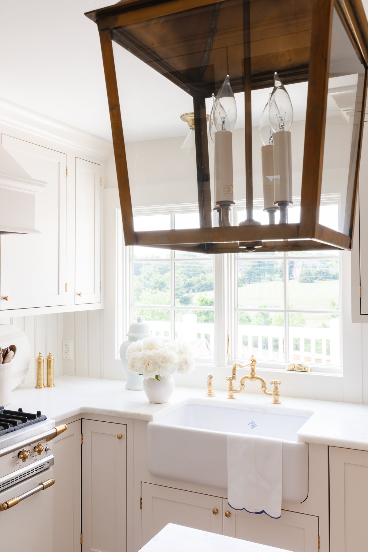 A minimalist kitchen with cream cabinets, marble countertops and a French range.