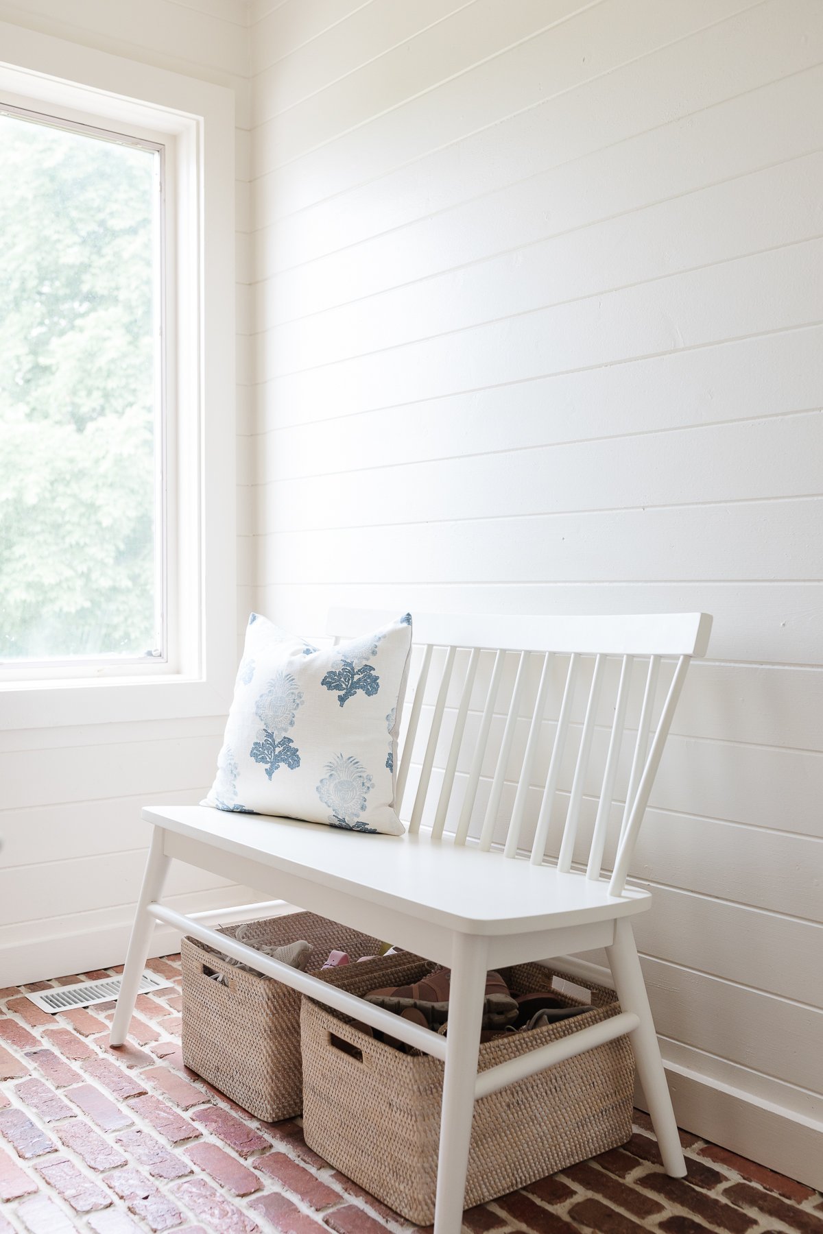 A mudroom bench with storage baskets underneath.