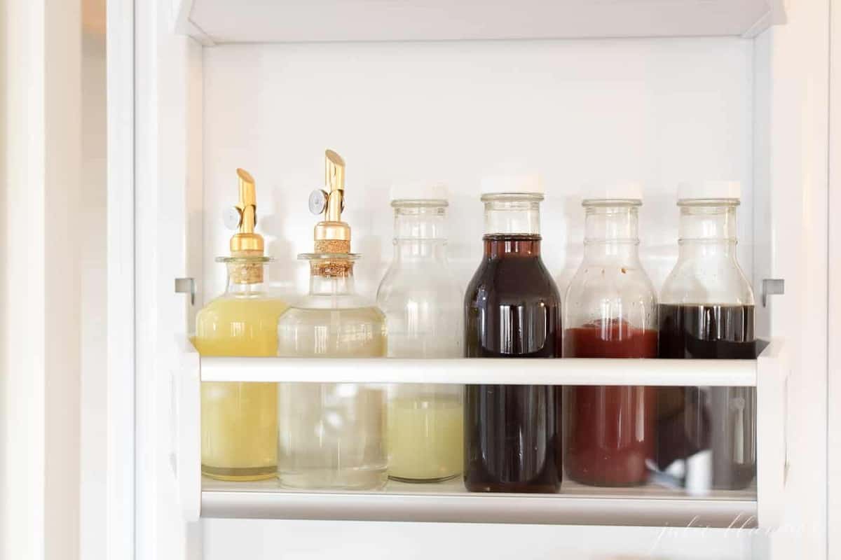 Glass storage bottles inside a refrigerator.