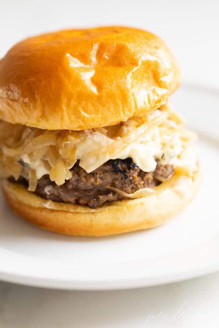 White surface, white place featuring a gourmet burger on a brioche bun.