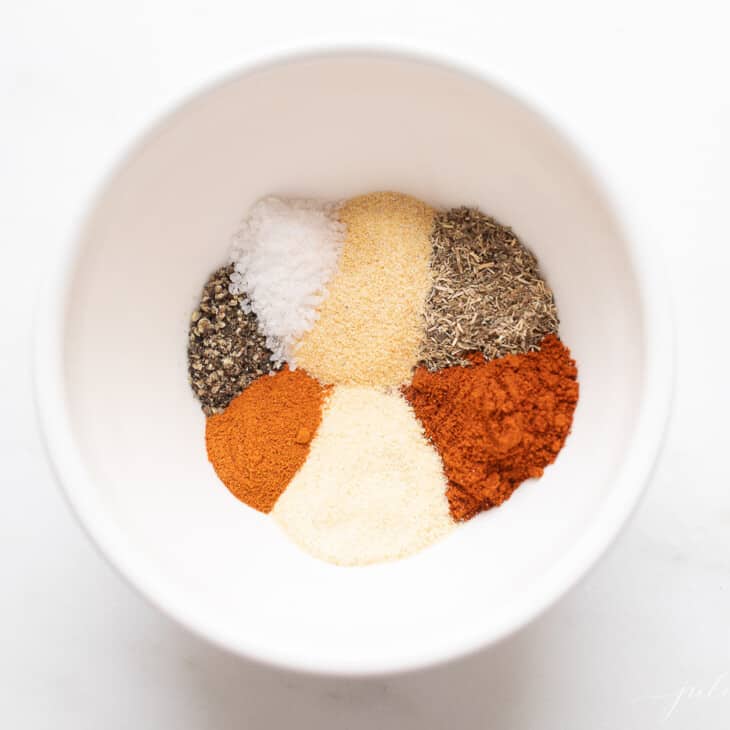 A white bowl with a blend of seven spices to make blackened seasoning.