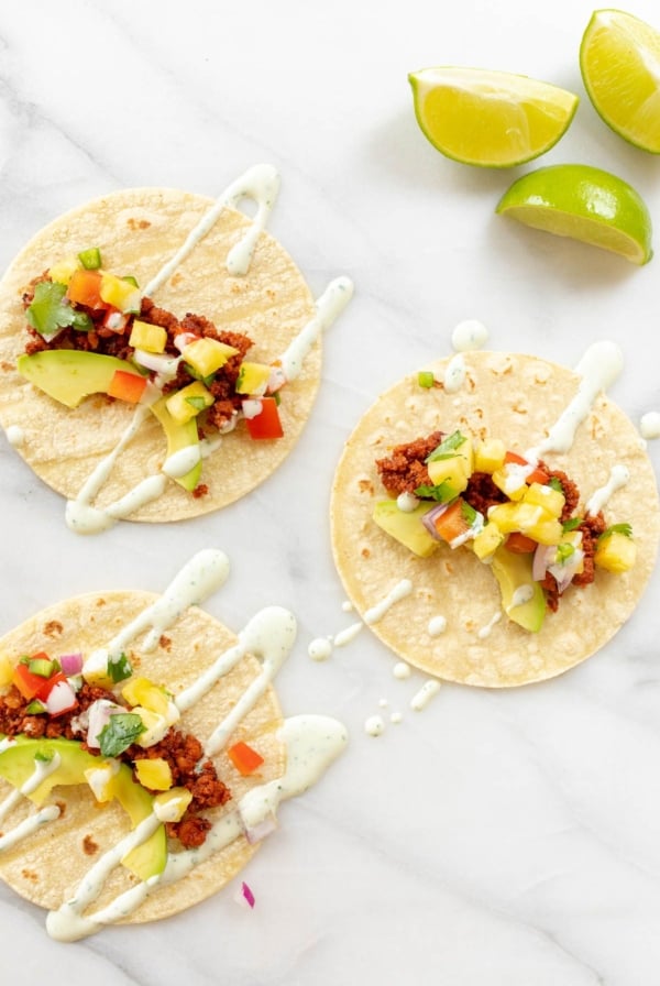 Chorizo tacos topped with avocado, pineapple and lime crema.