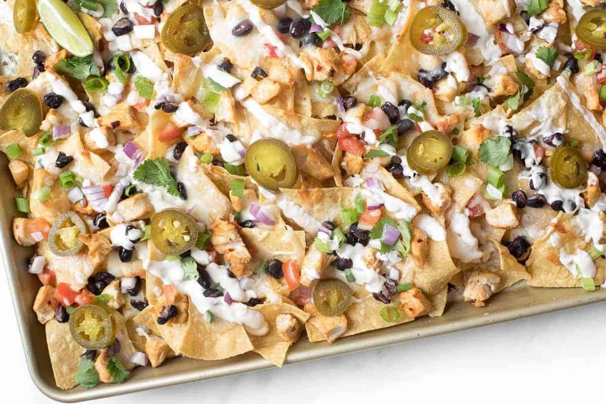 A gold baking sheet filled with nachos.