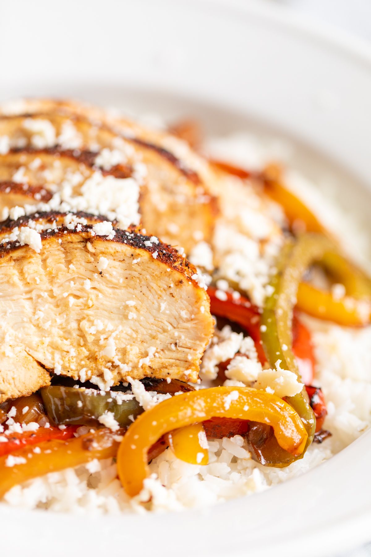 A chicken fajita bowl served over white rice and sauteed peppers.