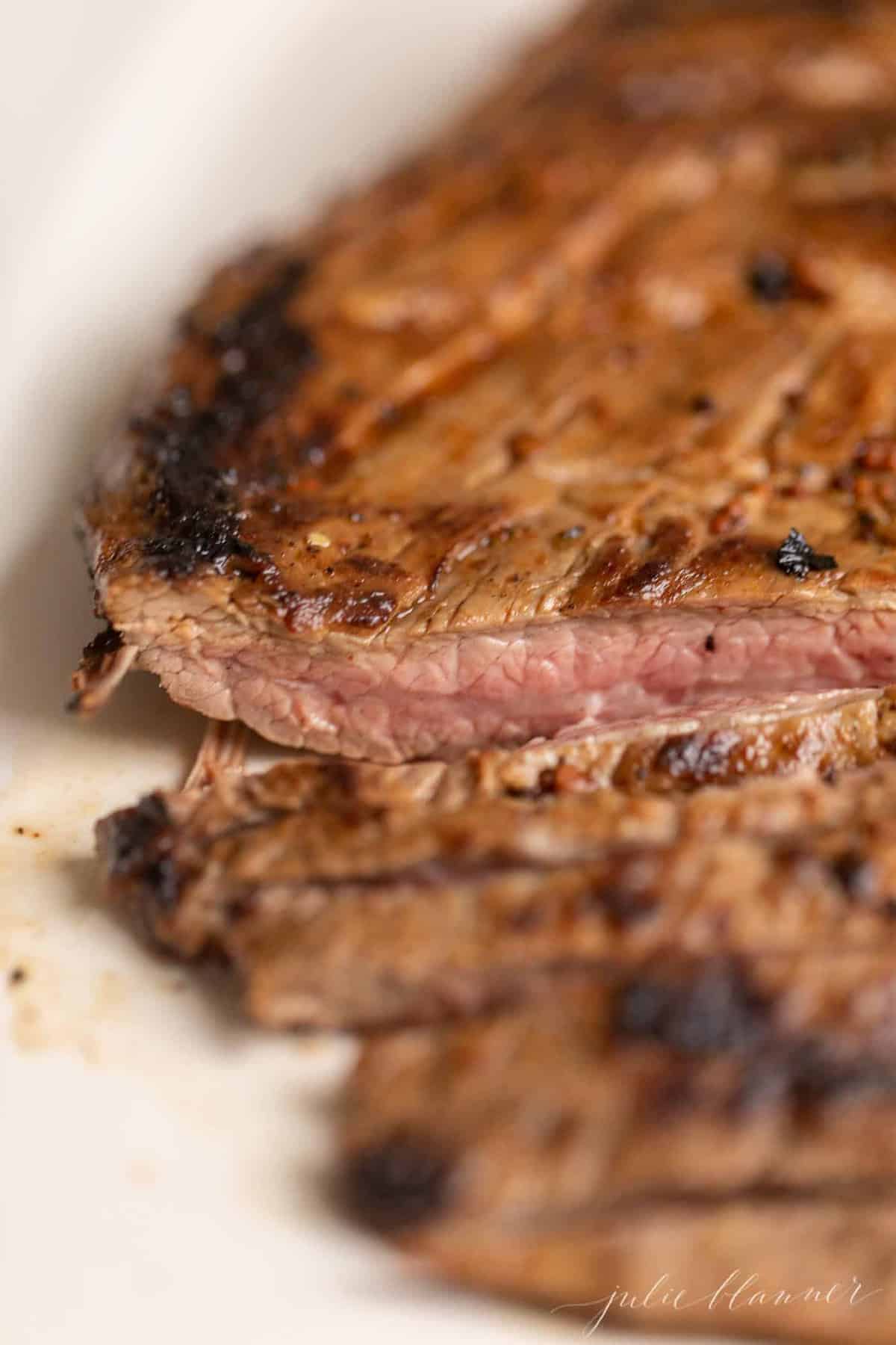 A closed up of pan fried steak, sliced.