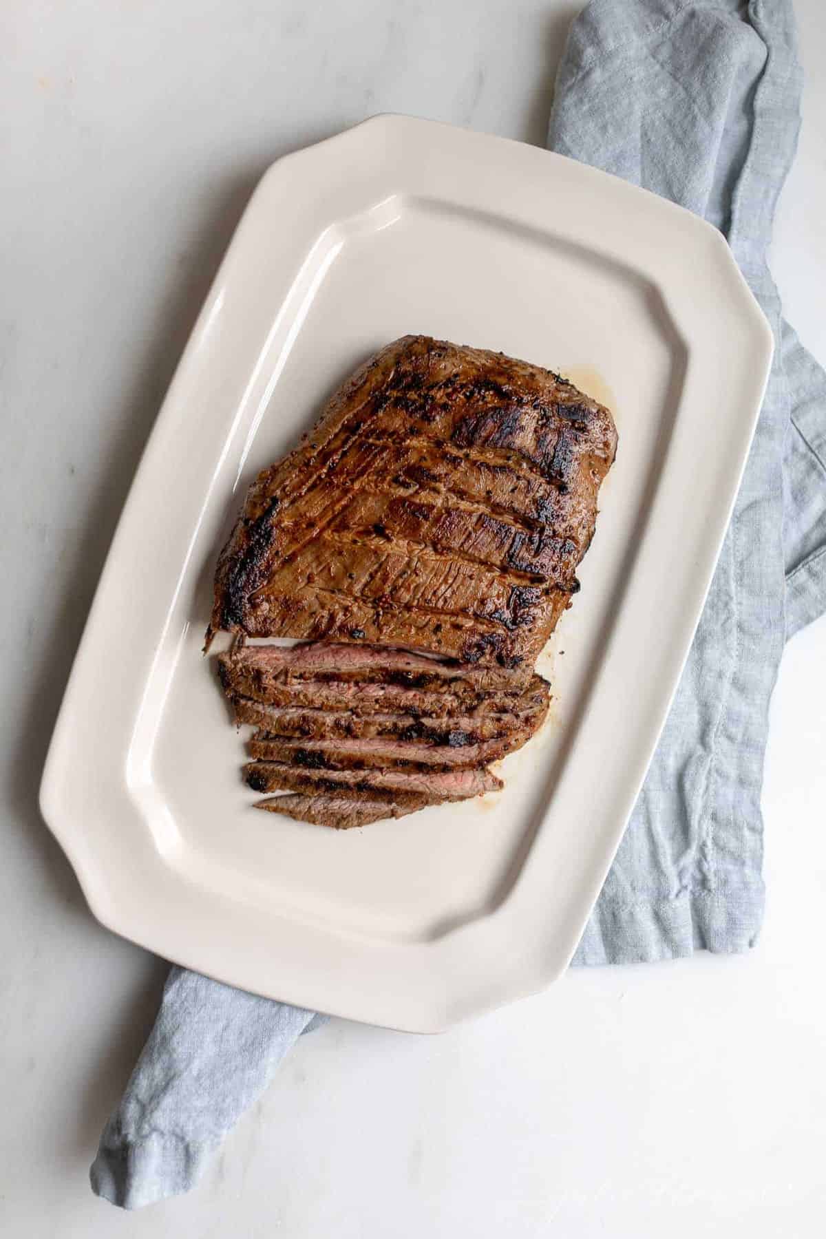 A flank steak after being pan fried on the stove, sliced.