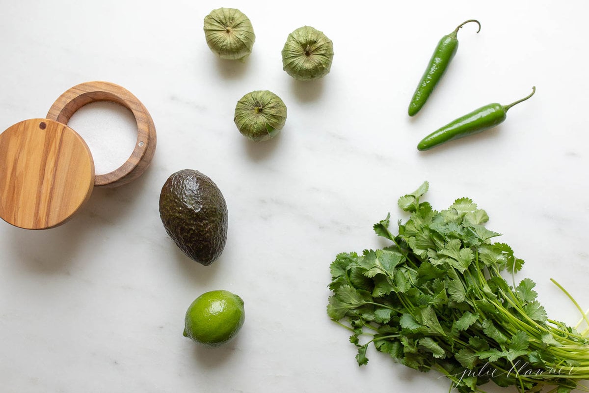 Ingredients for guacamole salsa on a marble countertop