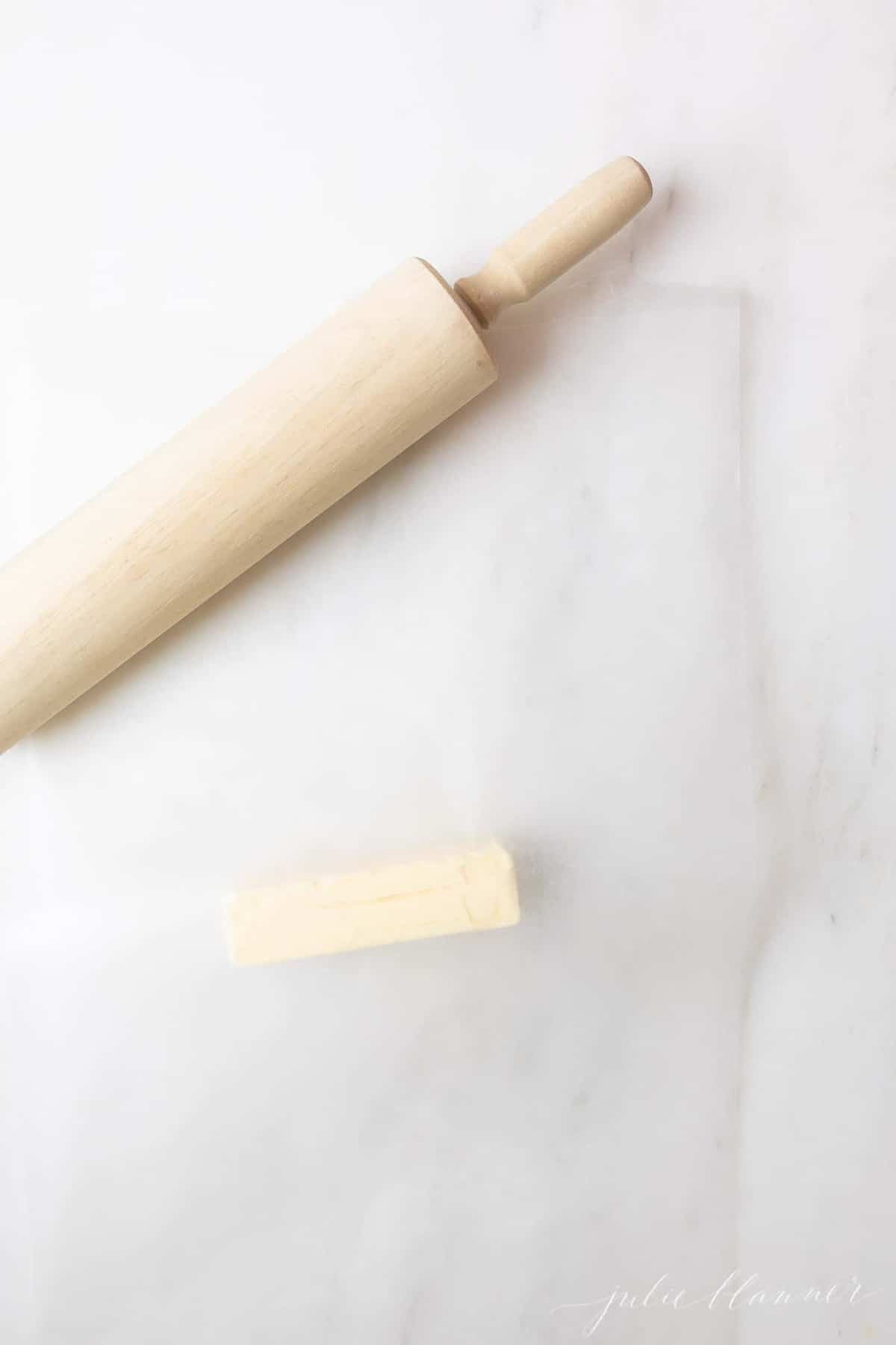 Marble surface, stick of butter and rolling pin.