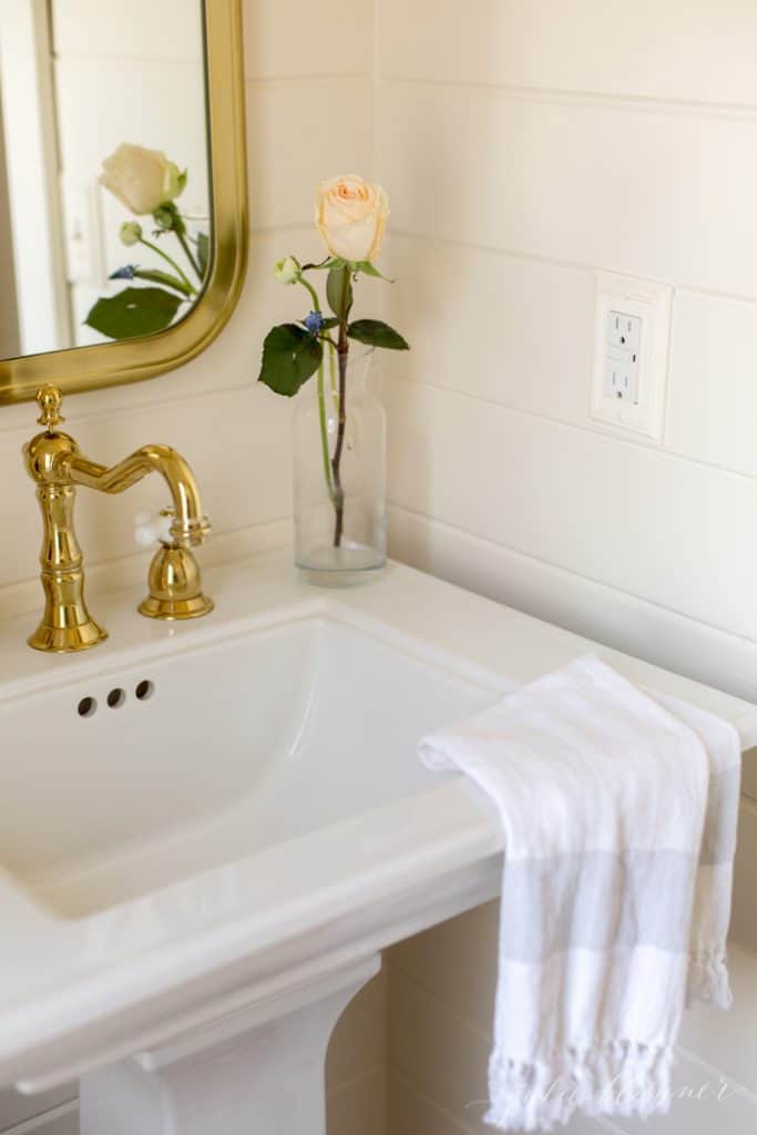 A remodeled bathroom with gold accents. 