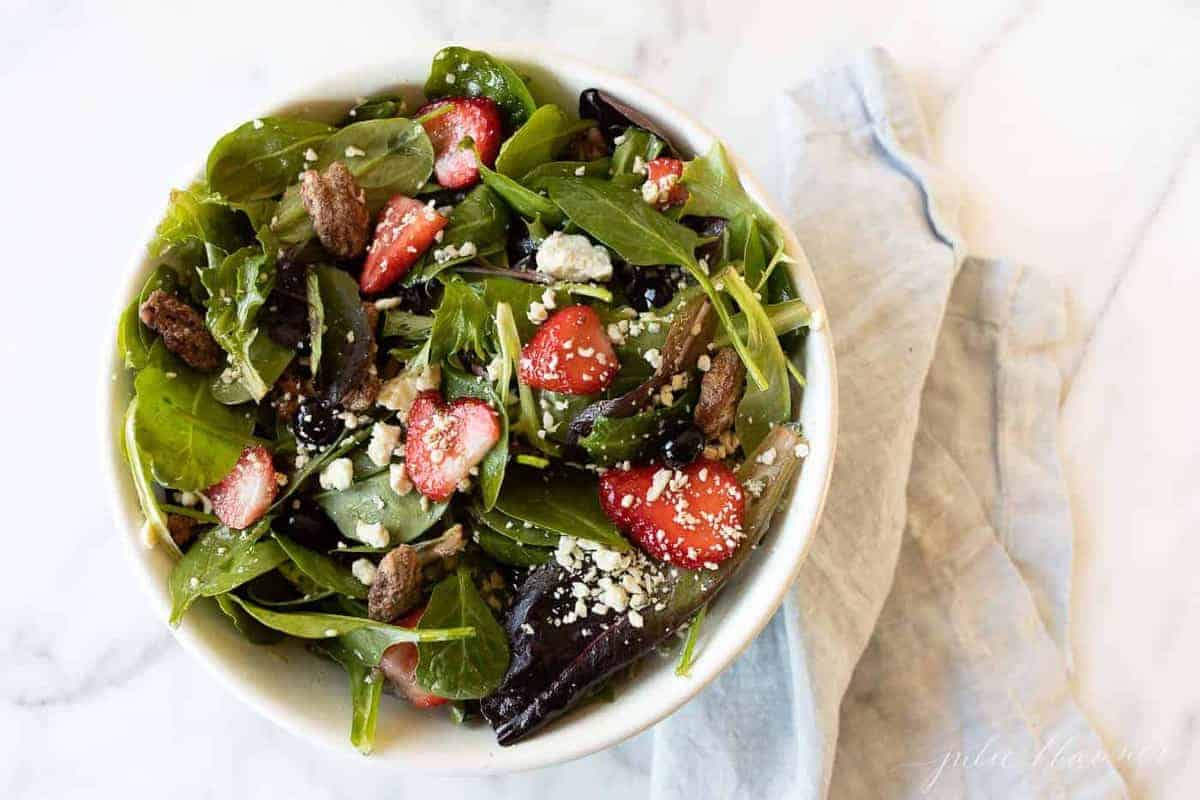 A white bowl full of a fresh spring salad mix recipe