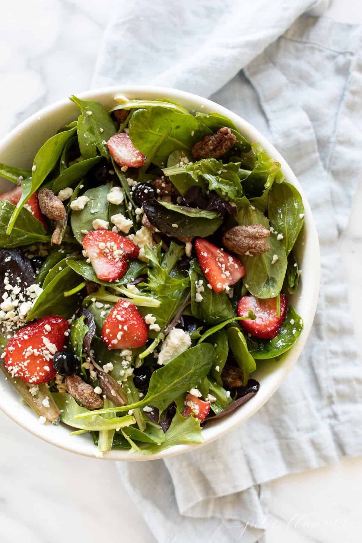 A white bowl full of a fresh spring salad