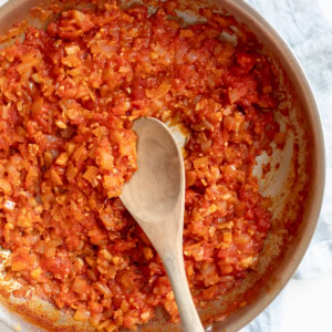 A skillet with simmering amatriciana sauce.