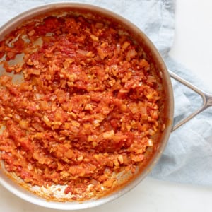 A skillet with simmering amatriciana sauce.