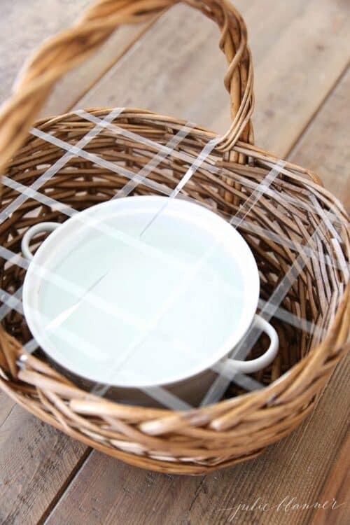 A wicker basket with a white dish inside, preparing to make a flower basket.