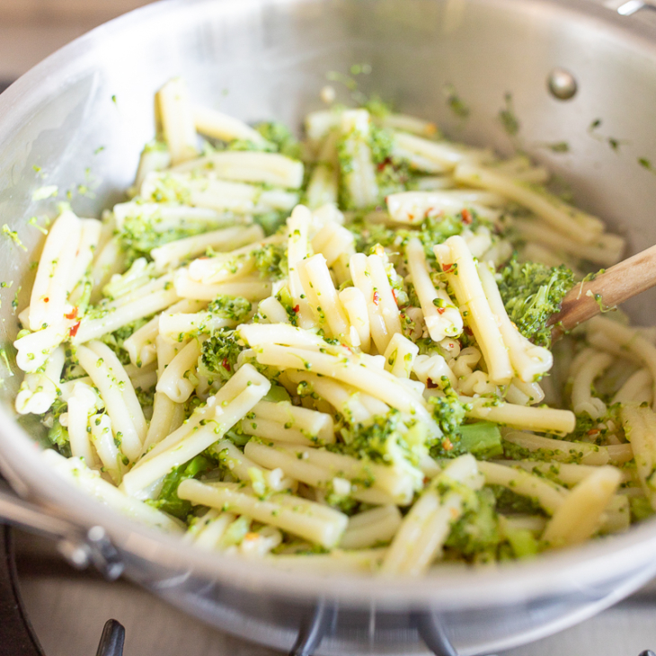 A broccoli pasta recipe inside a stainless steel pot on a stovetop