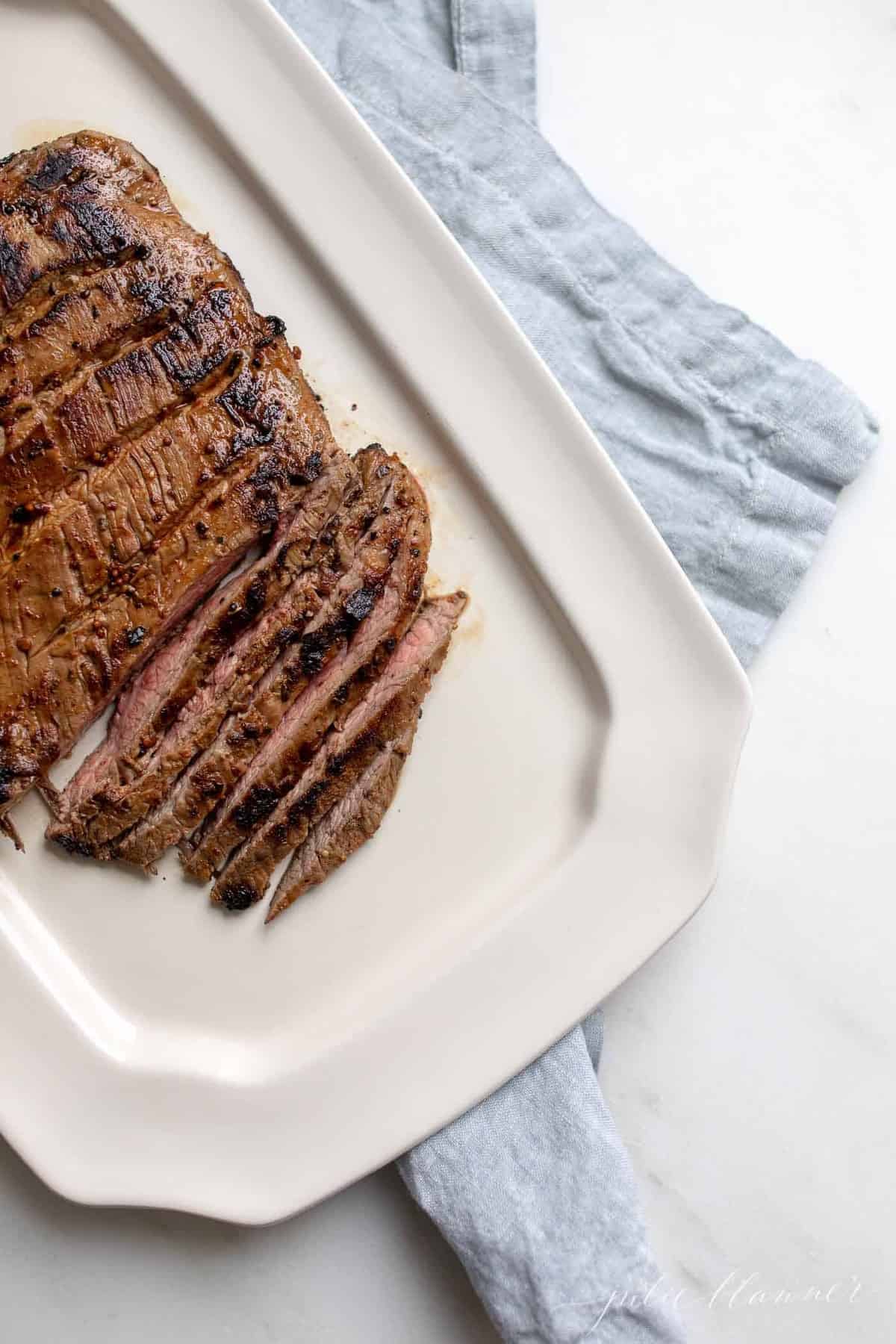 White platter with sliced carne asada