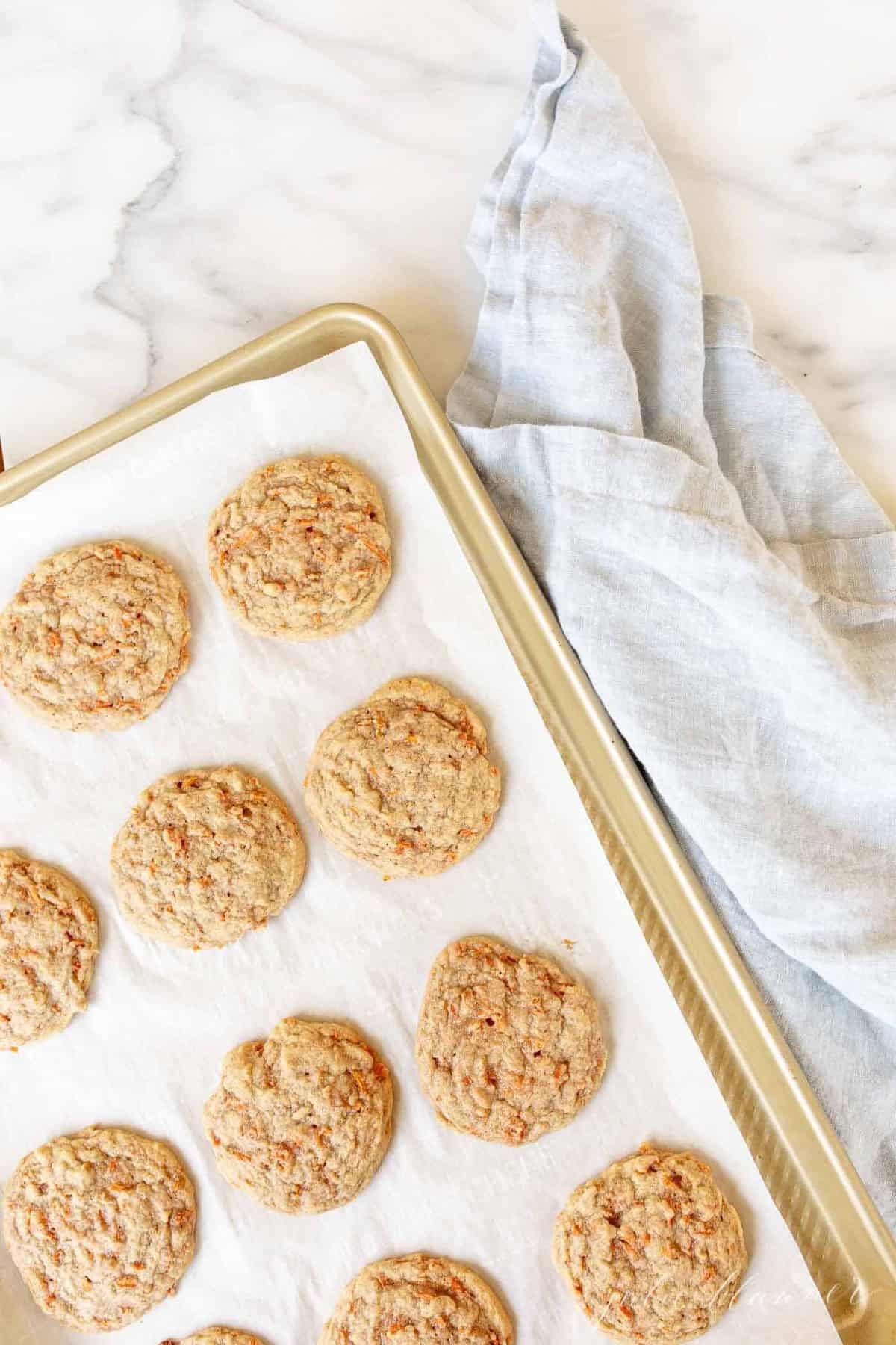 Gold baking sheet with carrot cookies.