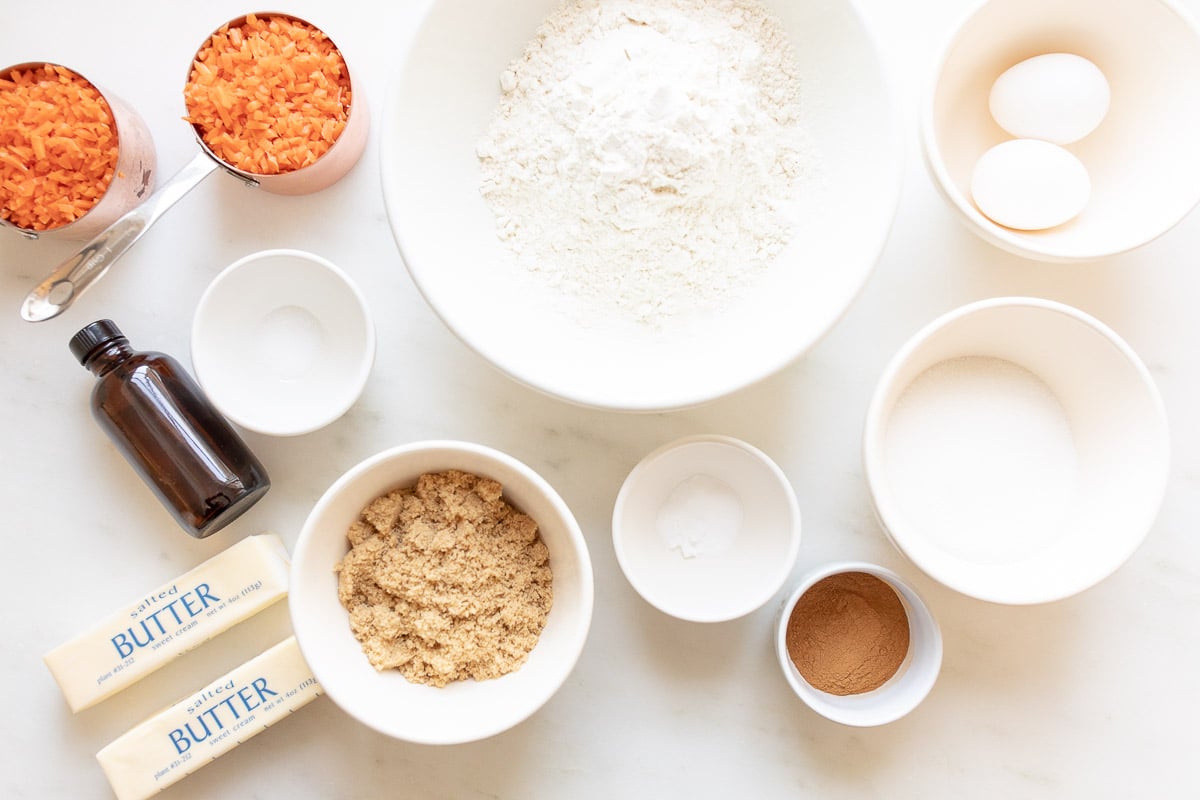 The ingredients for carrot cake muffins are laid out on a table.