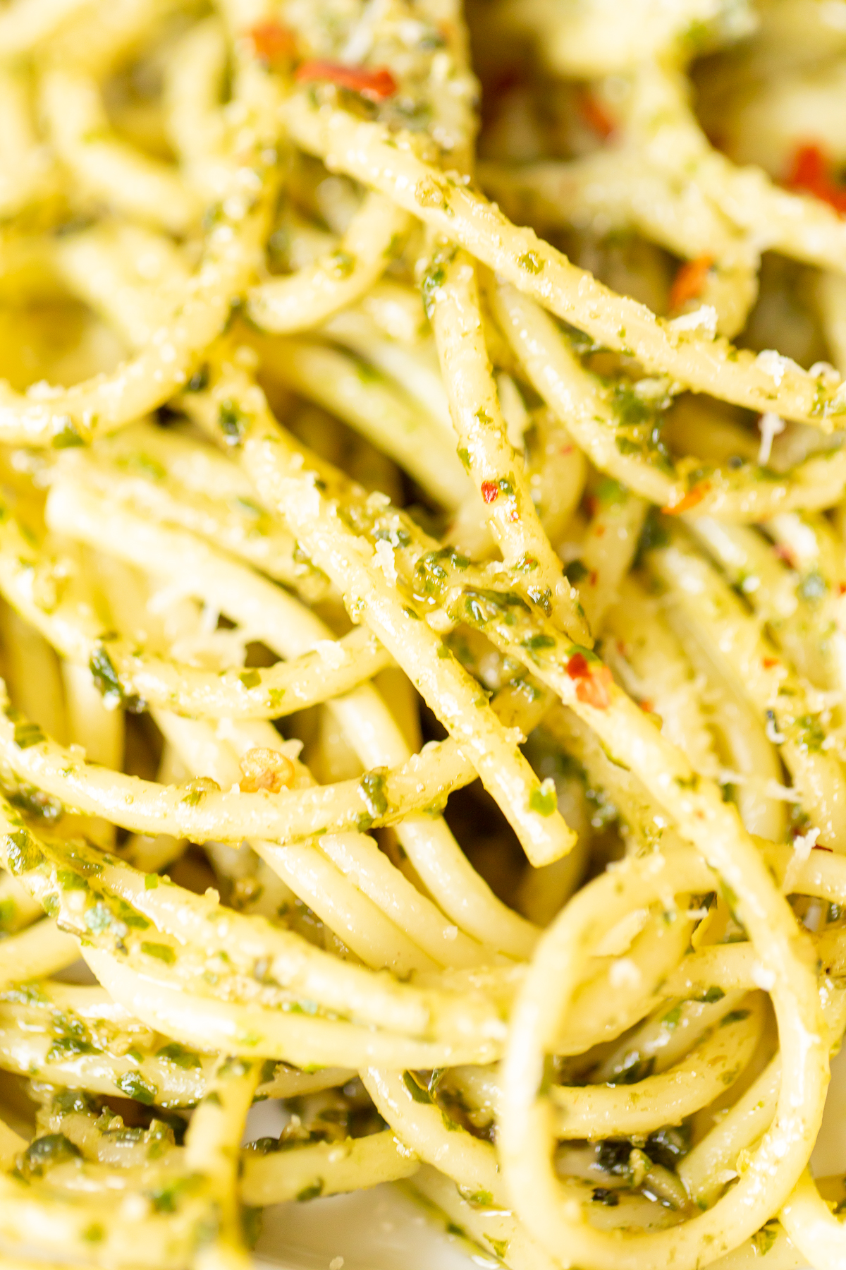 A plate of spaghetti with pesto pasta on it.