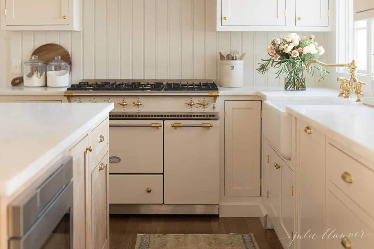 A cream cabinet with an apron front farmhouse sink.