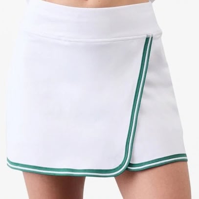 A person wearing a white tennis skirt with green trim and a wrap-style front, shown from the waist to mid-thigh.