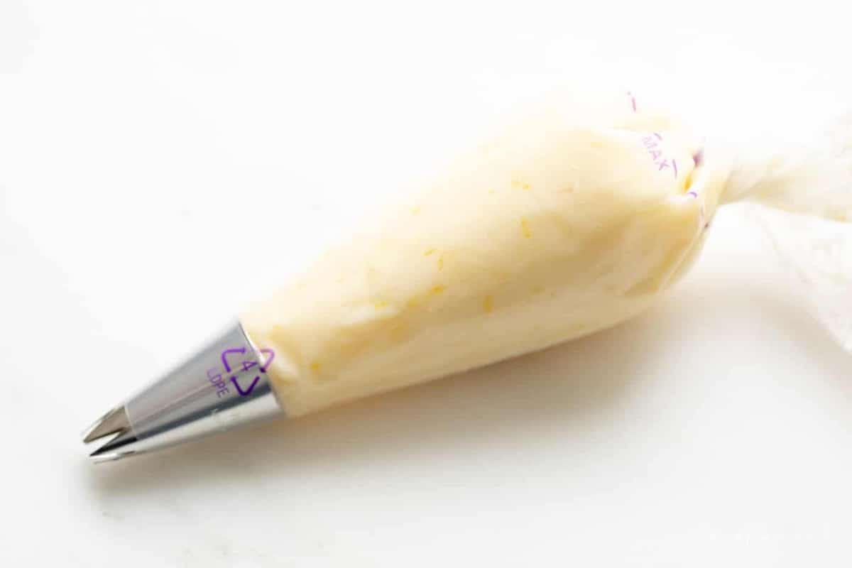 A piping bag full of lime frosting for a lime cookie recipe.