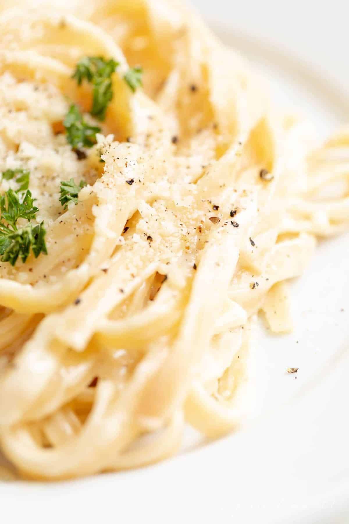 Close up of fettuccine noodles covered in an alfredo sauce recipe