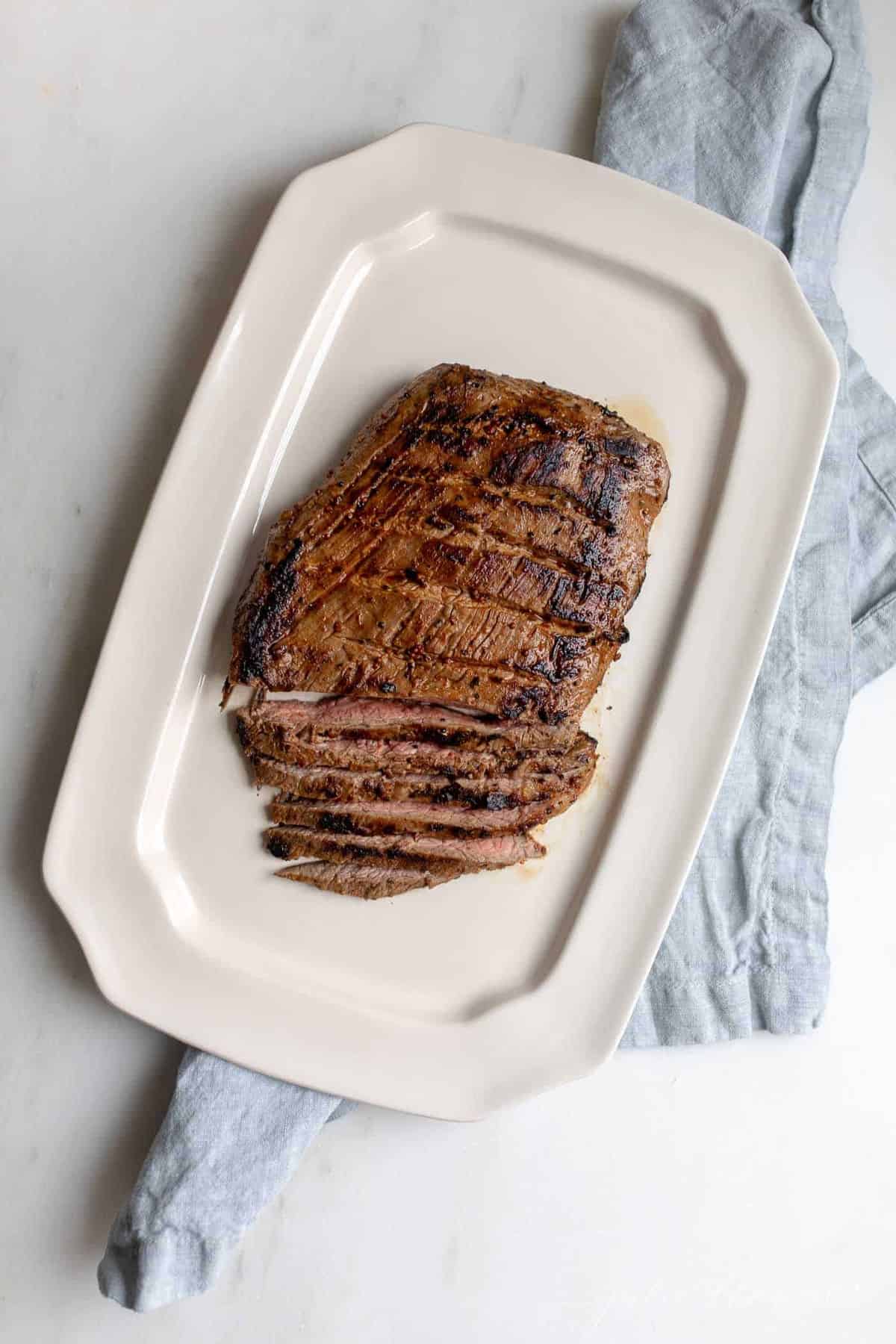 White platter with sliced carne asada