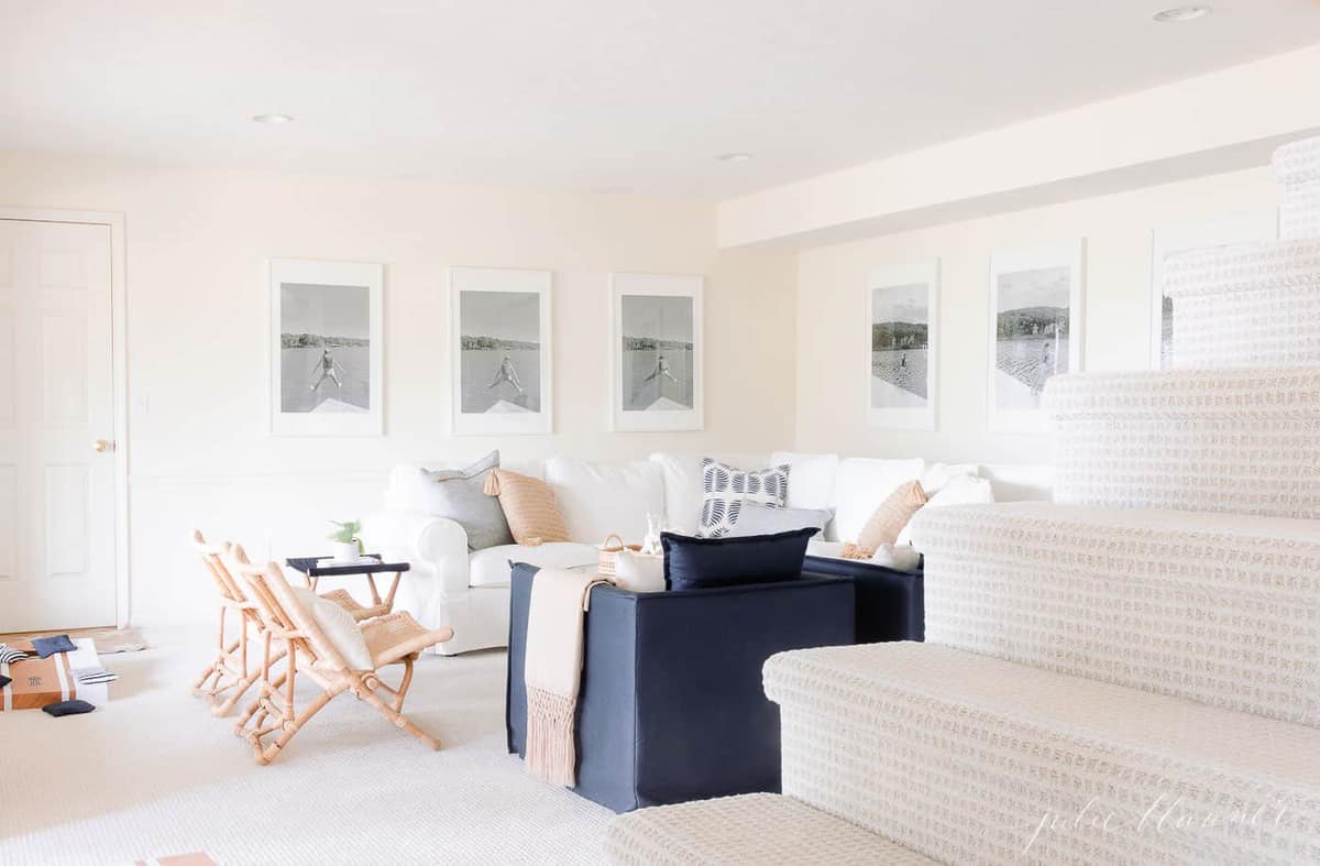 lake house living room with soft cream walls and carpet navy and white furniture