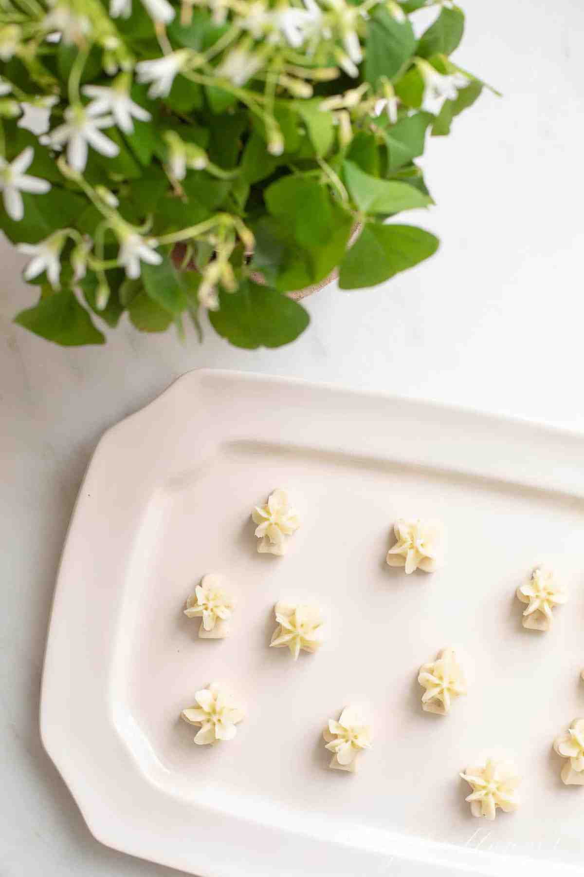 Tiny key lime cookies with frosting on a white surface.