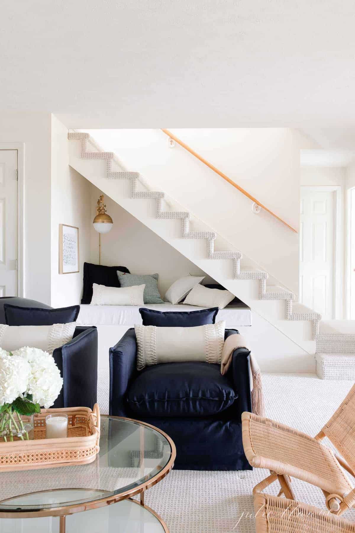 navy chairs and gold coffee table in front of under stairs nook