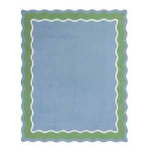 Rectangular light blue rug with wavy green and white borders.