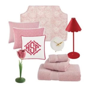 A collection of pink and red bedroom decor items, including pillows, towels, a lamp, a clock, a flower in a vase, and a patterned headboard.