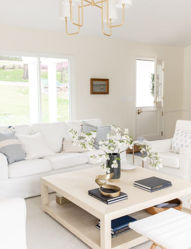 coastal style living room with white slipcovered sofas and dutch door