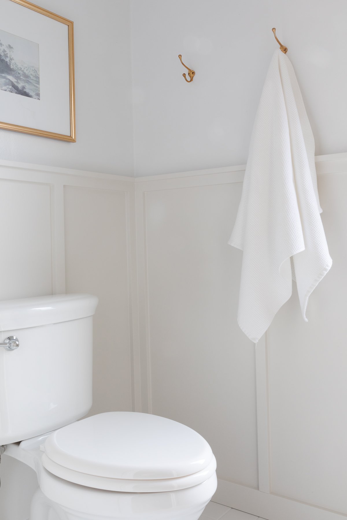 a small bathroom with beige board and batten on the walls 