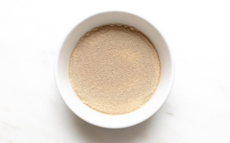 A marble countertop with a bowl of instant yeast beginning to activate