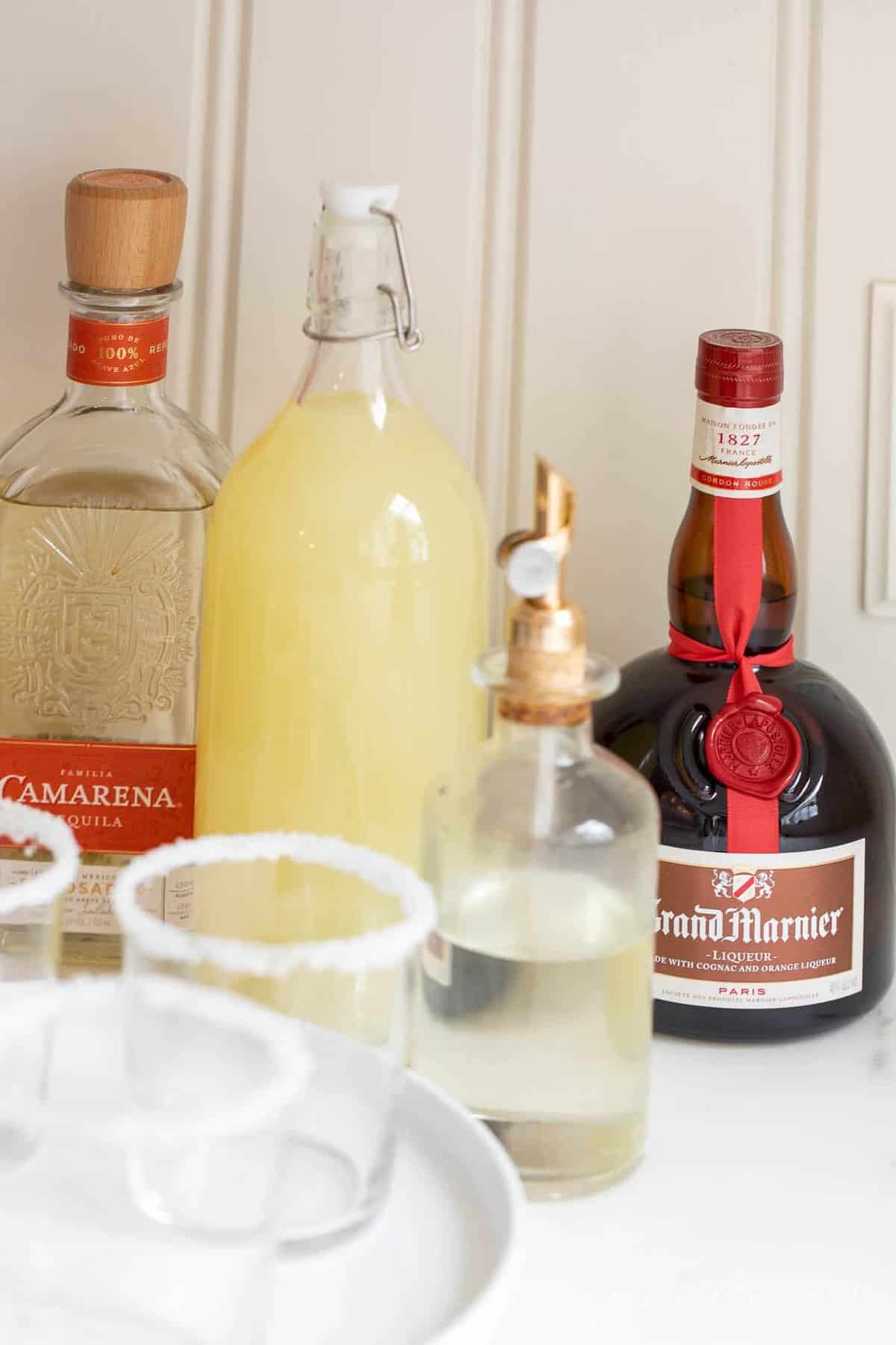 A set up of bottles preparing to make margaritas, with expensive tequila bottle