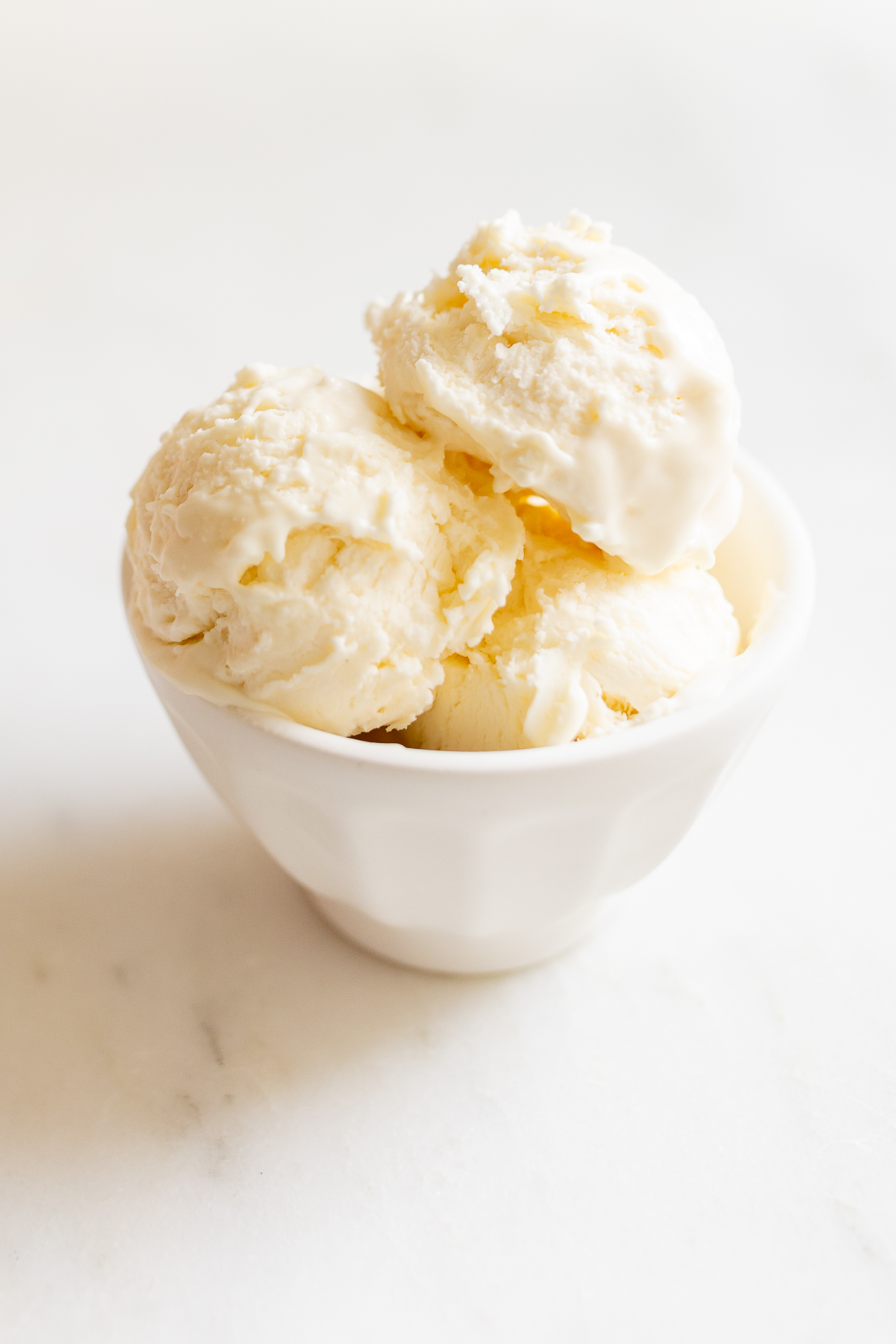 condensed milk ice cream in a white bowl on a marble countertop
