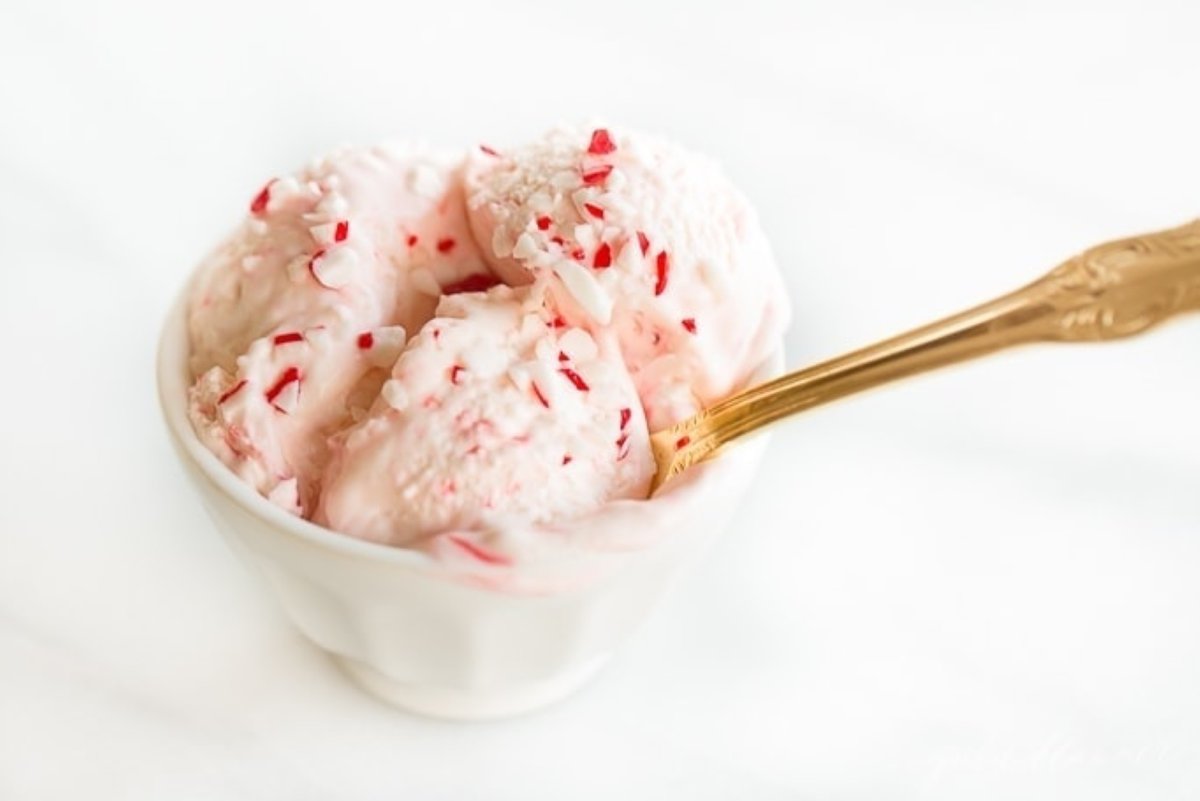A white bowl of peppermint condensed milk ice cream, with a gold spoon.