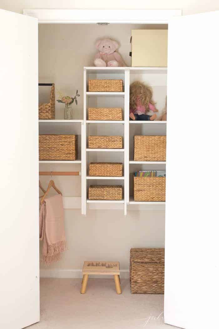 An organized child's closet filled with matching seagrass woven baskets.