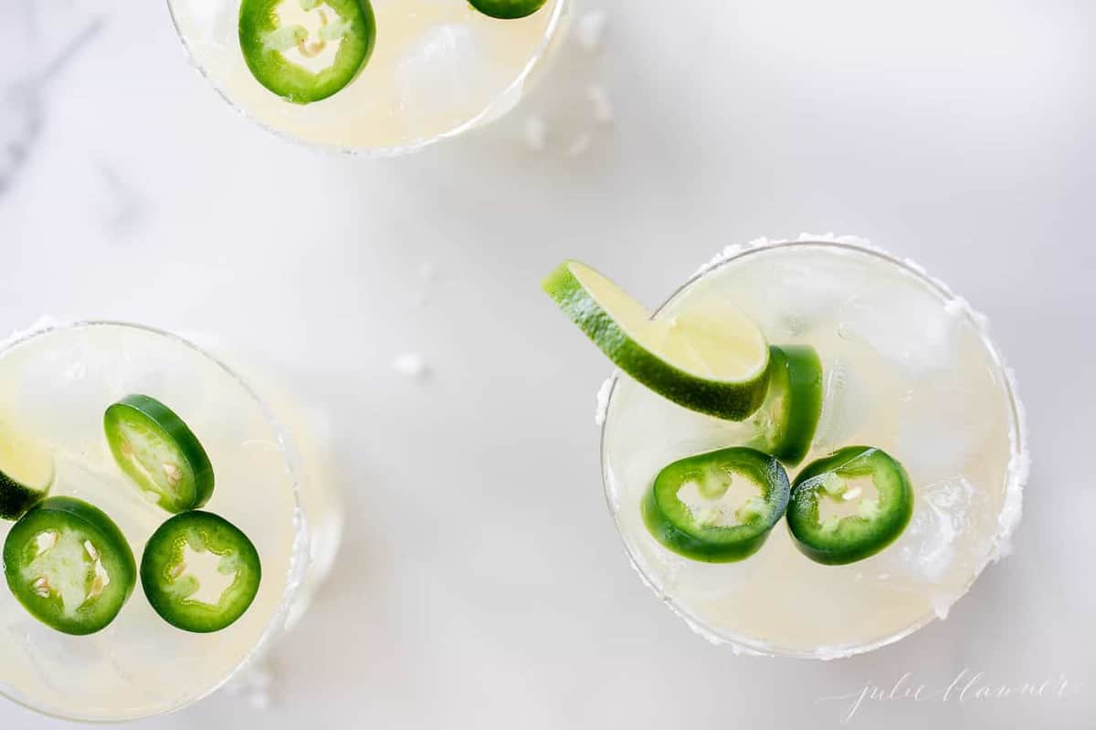 Marble surface, three glasses full of jalapeno margaritas.