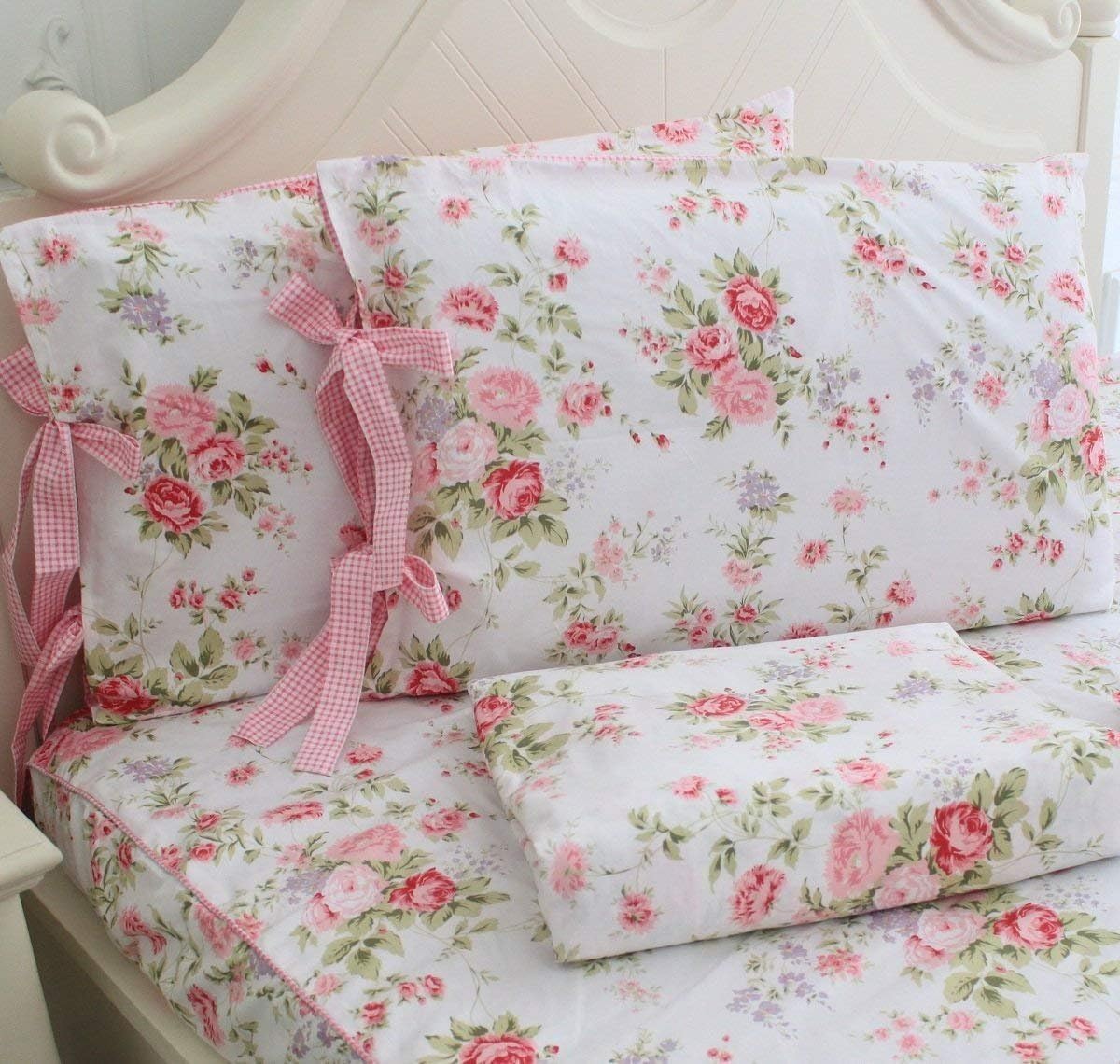 A set of girls bunk beds with floral-patterned sheets and pillows decorated with pink and red flowers. The pillows have pink checkered ties on the sides.
