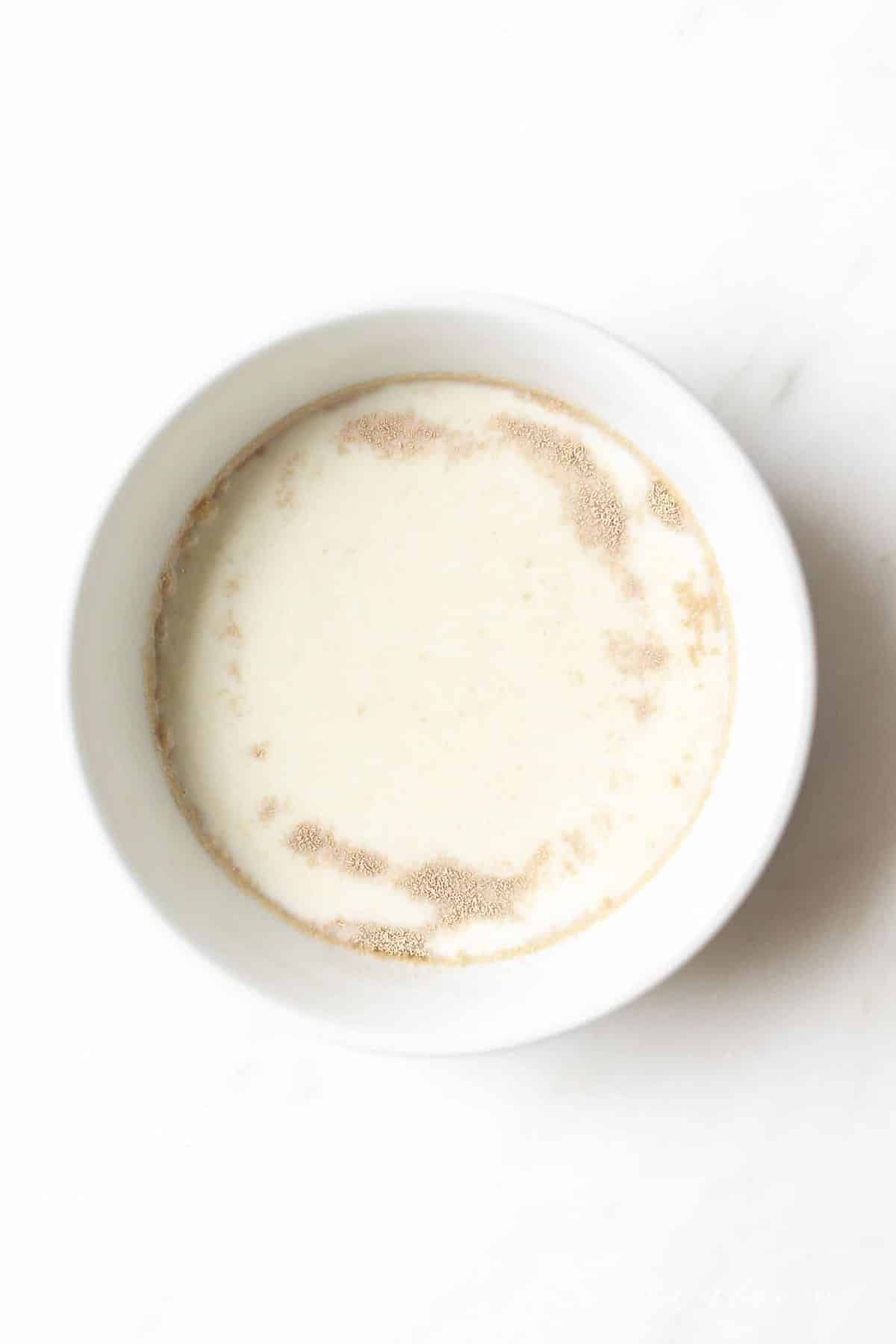 A marble countertop with a bowl of instant yeast beginning to activate