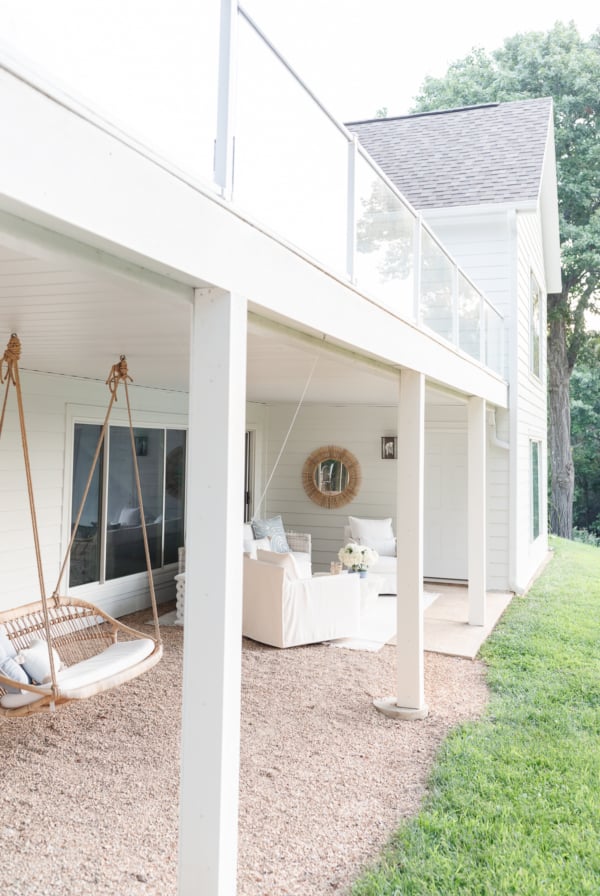 A white porch with a swing and chairs is the perfect addition to your outdoor living space.