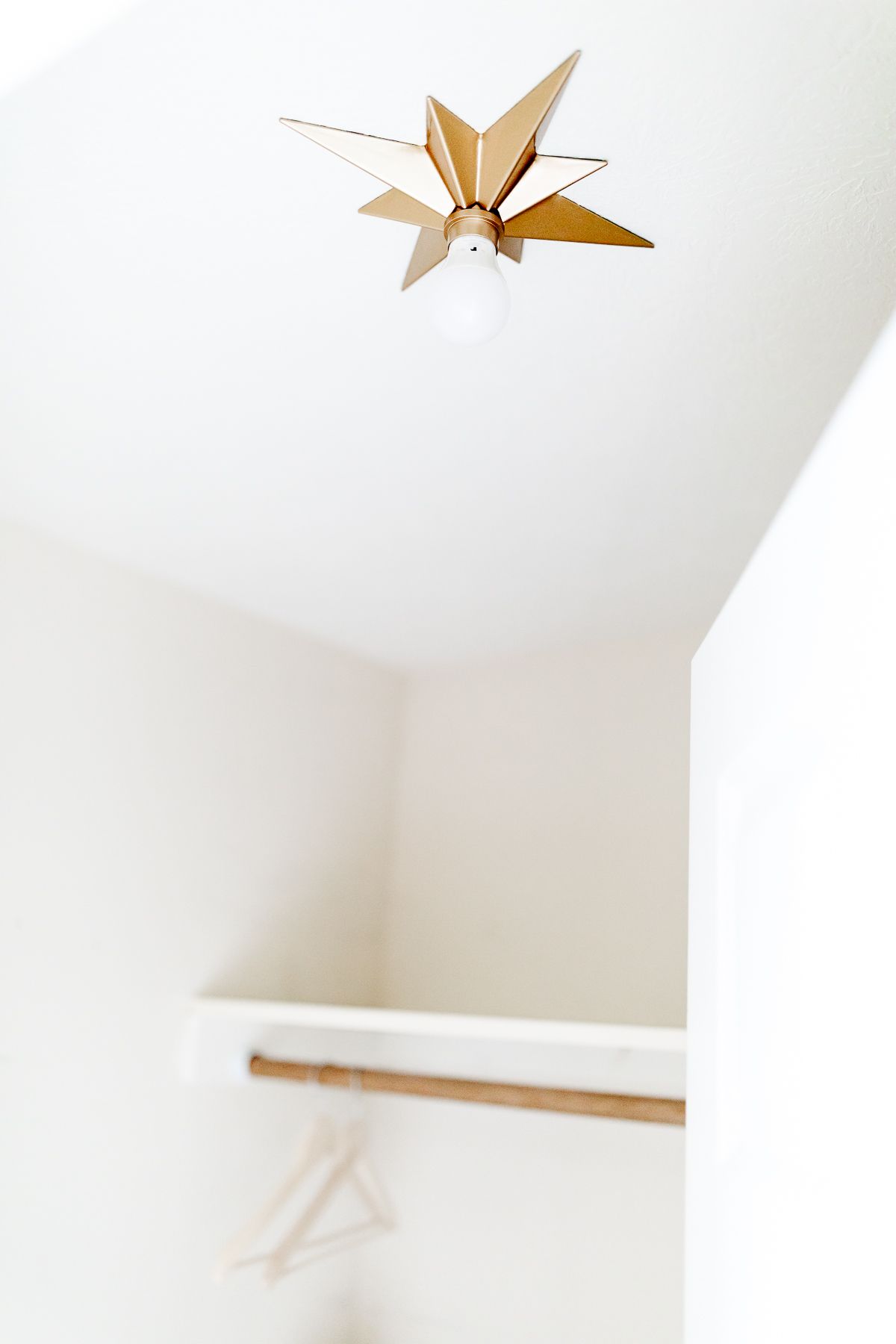 A star shaped gold ceiling light in a closet. 