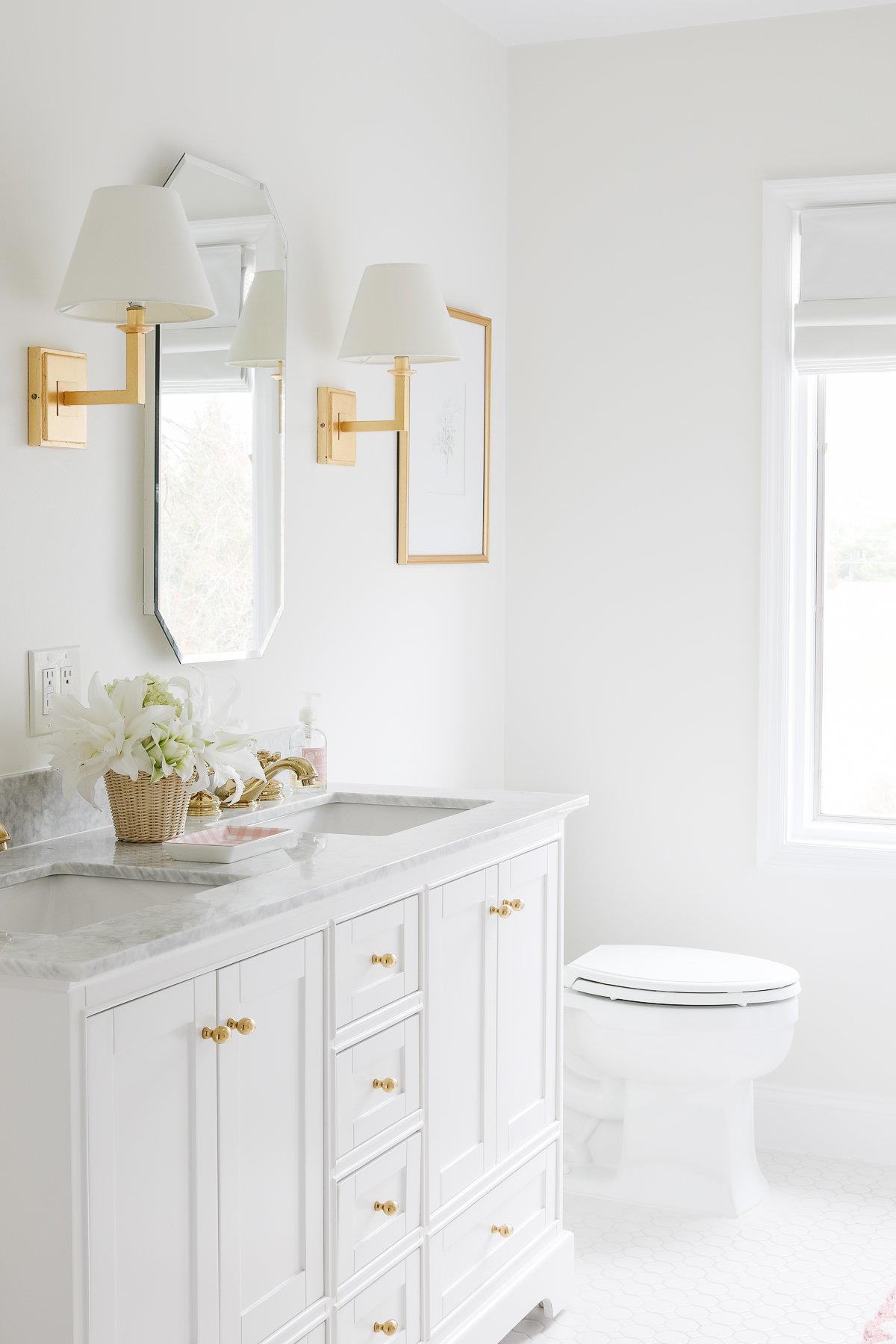 A white bathroom with gold accents, featuring Benjamin Moore White Dove trim.