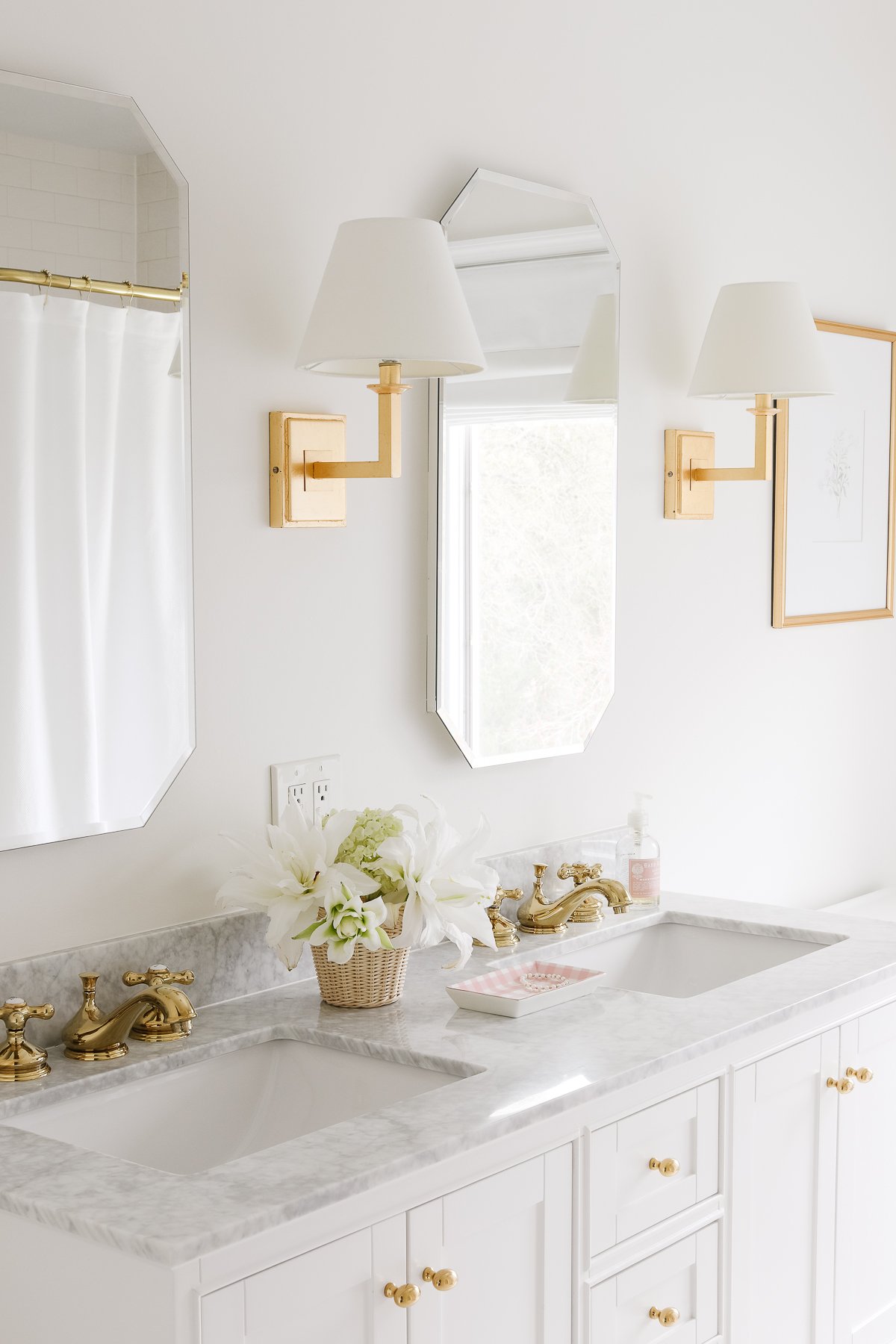 A white bathroom with two sinks and two mirrors, featuring Benjamin Moore White Dove trim.