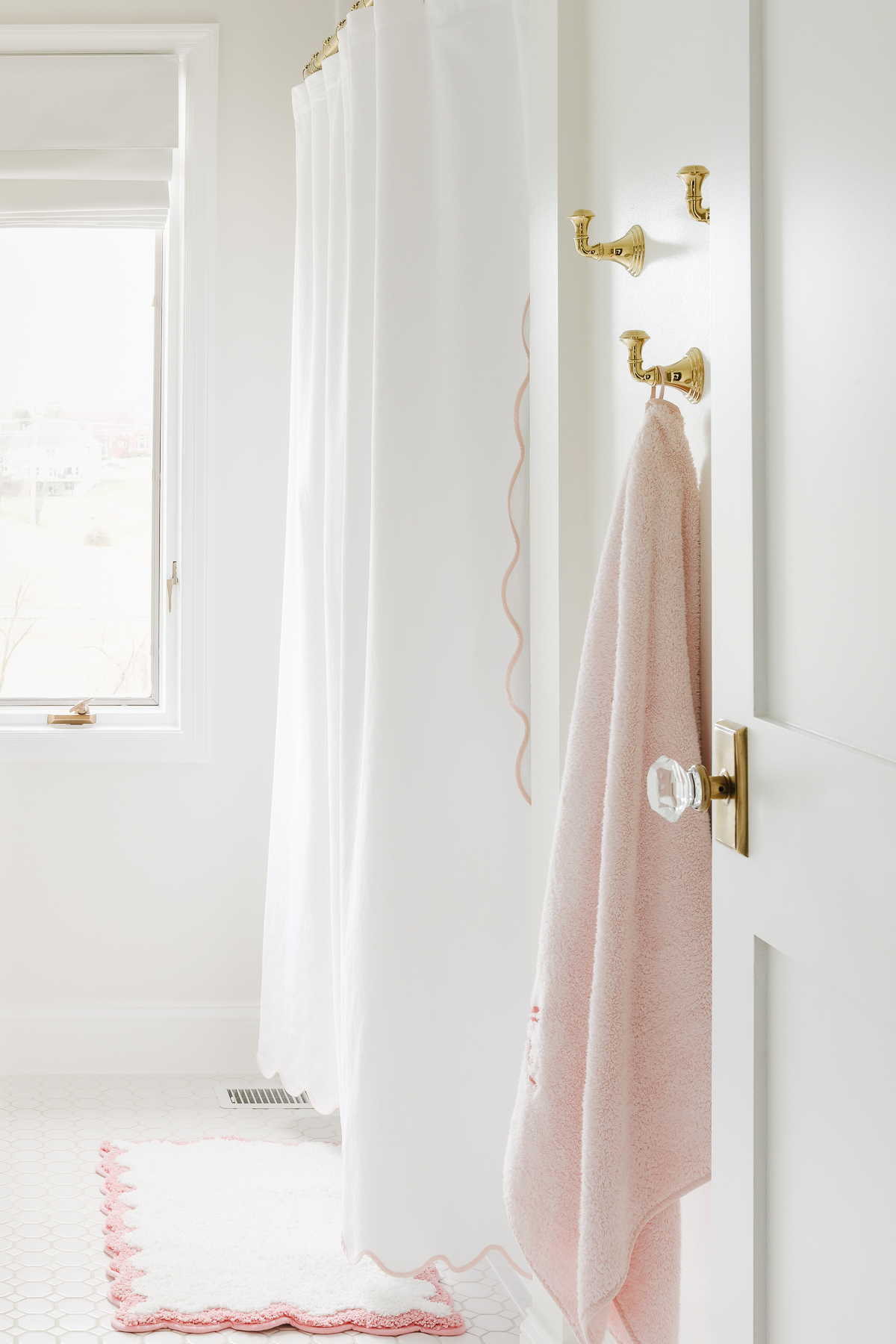 A Benjamin Moore White Dove painted bathroom with a pink rug and shower curtain.