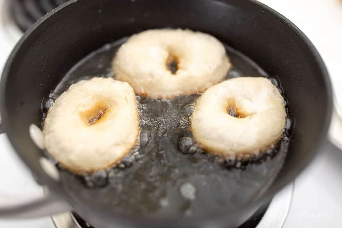 A sauce pan filled with oil frying easy homemade donuts.