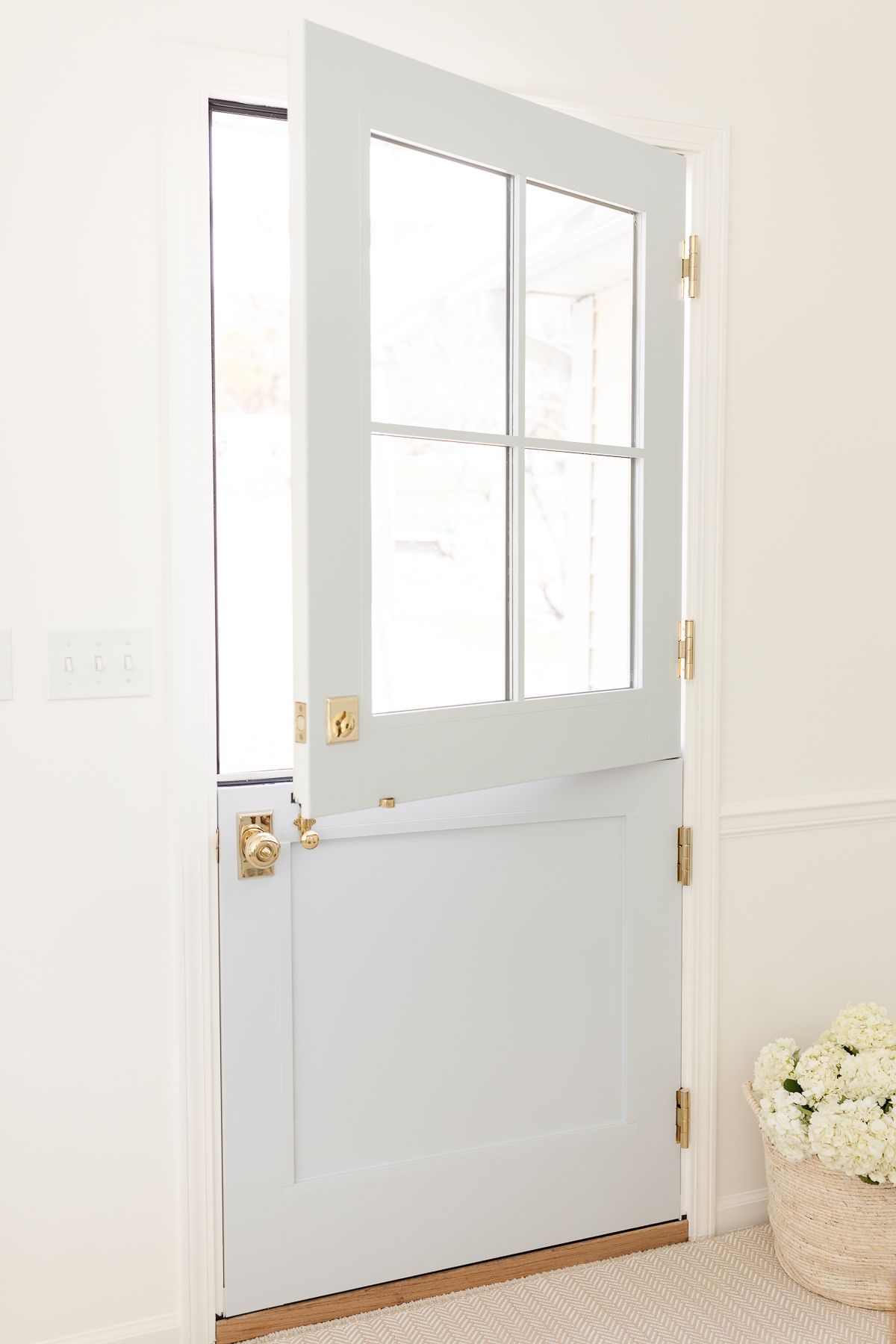 A soft blue dutch door in a bright white room